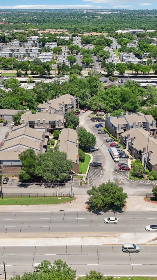 an aerial view of a residential neighborhood with trees and cars at The Cross Creek Apartments