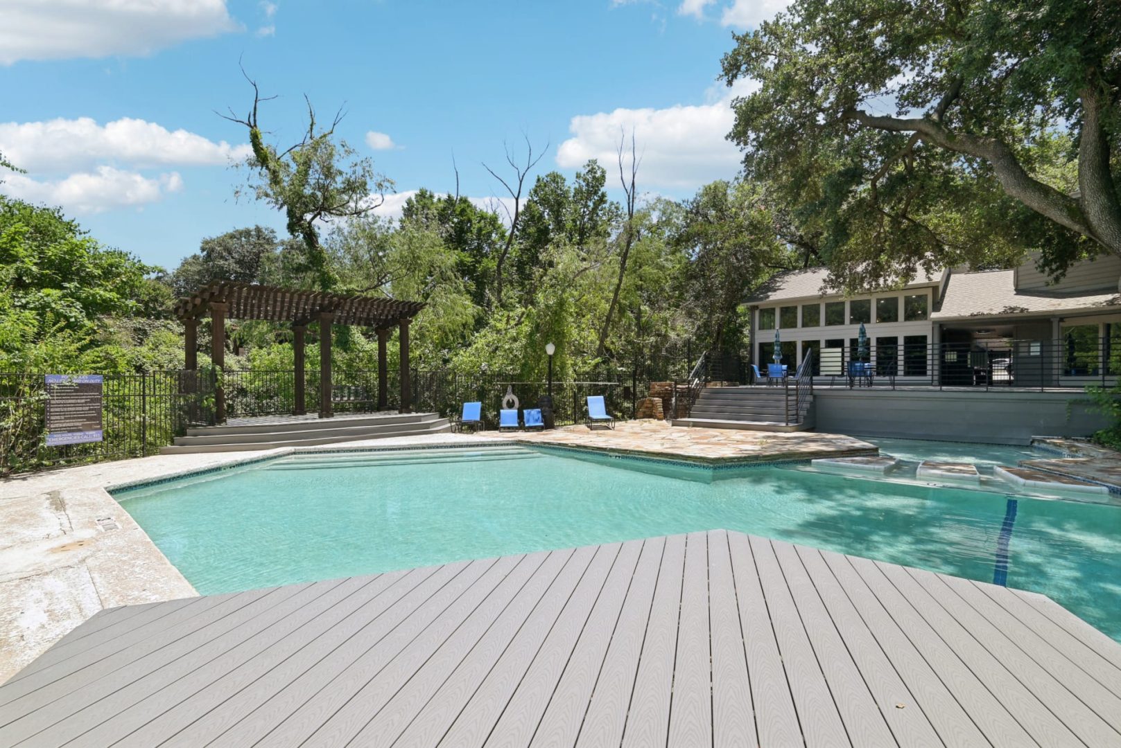 a pool with a deck and a deck chair at The Cross Creek Apartments