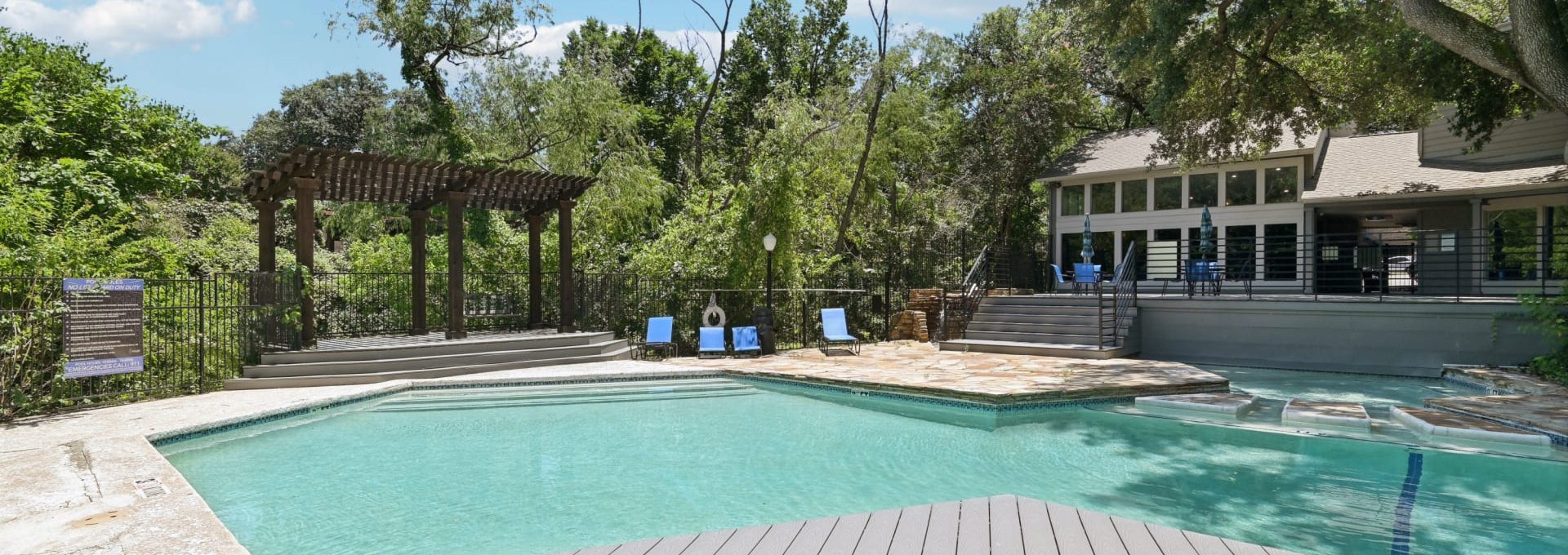 a pool with a deck and a deck chair at The Cross Creek Apartments