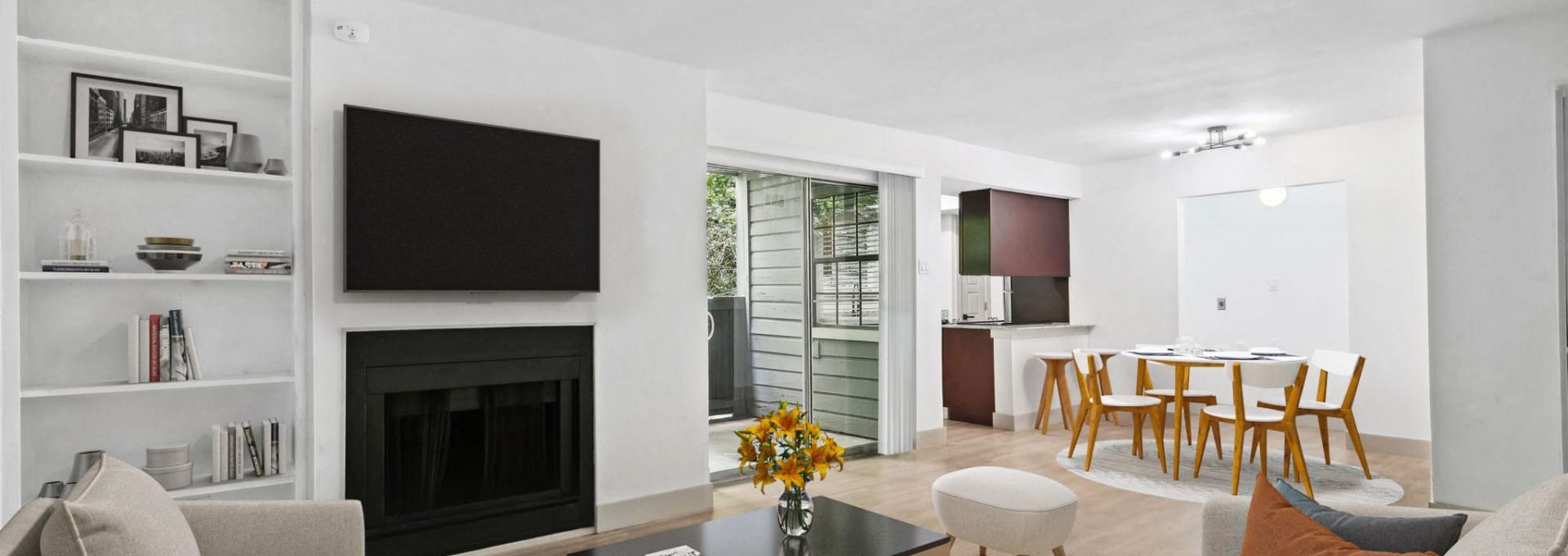 a living room with a fireplace and a television at The Cross Creek Apartments