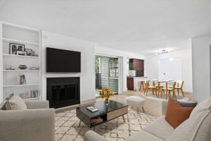 a living room with a fireplace and a television at The Cross Creek Apartments