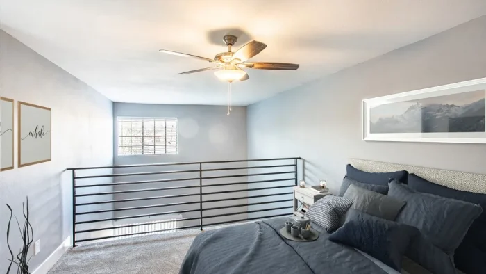 a bedroom with a ceiling fan and a bed at The Cross Creek Apartments