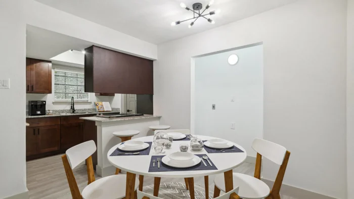 a white table and chairs in a small kitchen at The Cross Creek Apartments