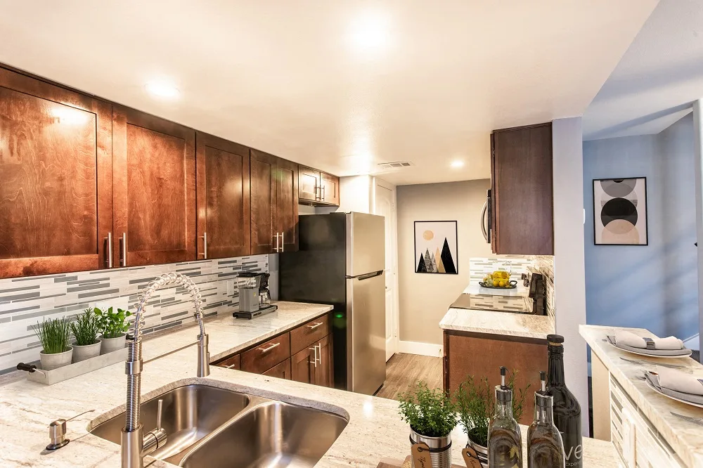 a kitchen with stainless steel appliances and wood cabinets at The Cross Creek Apartments